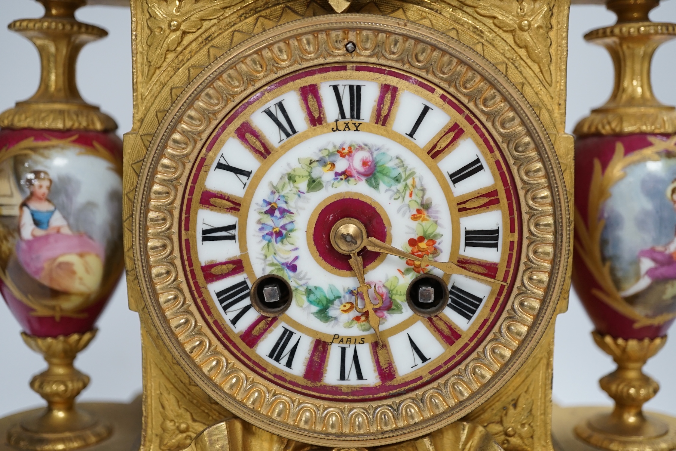 A late 19th century gilt spelter and porcelain mantel clock with two stands, a case, key and pendulum. Condition - fair to good. Not tested.